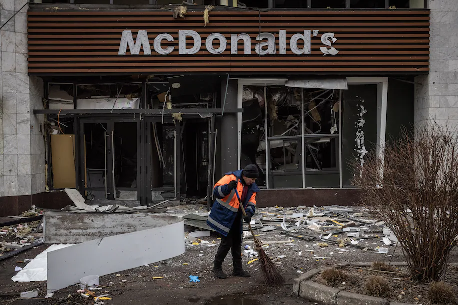 У суботу в Шевченківському районі Києва працівник прибирає сміття біля ресторану McDonald's, який сильно постраждав від нічного російського ракетного удару